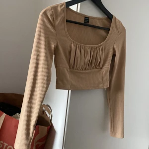 Beige croptop - Säljer denna topp från shein med räfflad detalj vid bröstet. Det är en väldigt söt tröja men jag gillar inte riktigt att den är så kort så därför säljer jag denna.