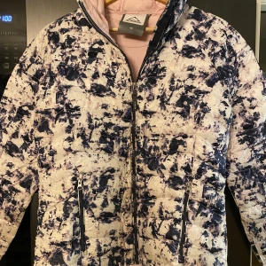 McKinley dunjacka stl 40 - McKinley lättviktsjacka, dun, flerfärgad, stl 40. Två fickor fram med dragkedja, huva. Yttertyg 100 % Polyester. Foder 100 % Nylon. Fyllning 90 % Dun 10 % Fjäder.  Fint skick. Finns i Södra Sunderbyn. Rök- och djurfritt hem. 