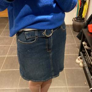En fin mörkblå jeans kjol med skärp. Den är i väldigt bra skick. Säljer för att den inte kommer till användning. 