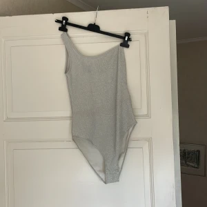 Body - Glittrig off shoulder body från H&M i använt skick men har inga tecken på användning. Storlek S. Skickar mer bilder om de efterfrågas. Fraktkostnad tillkommer 💕