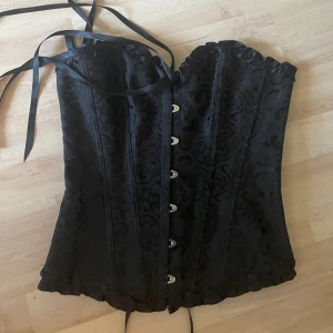Svart korsett - Säljer denna då den inte kommer till användning längre! Är i fint skick men köpt second hand, strl M men passar S med!