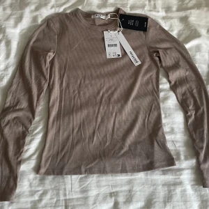Långärmad topp från NA-KD - Säljer denna brun/beiga topp från NA-KD, oanvänd, nypris 250kr. 🤍 