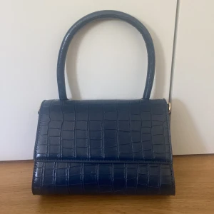 Marinblå handväska - Ny skick, jättefin färg. Livar upp en outfit! Säljer för jag behöver mer plats för andra väskor.