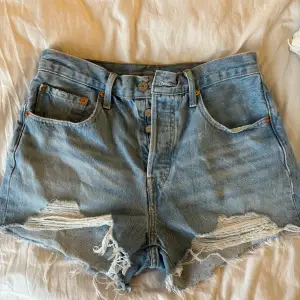 Ett par ljusblå jeansshorts från levi’s, modell 501. Storlek 27 (som en storlek s). Köpta i slutat av förra sommaren så i mycket bra skick då de bara använts några få gånger.