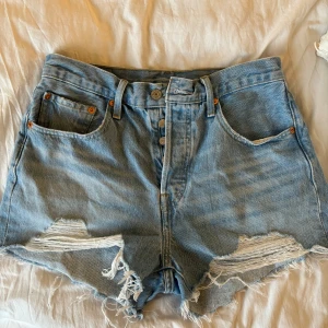 Jeansshorts - Ett par ljusblå jeansshorts från levi’s, modell 501. Storlek 27 (som en storlek s). Köpta i slutat av förra sommaren så i mycket bra skick då de bara använts några få gånger.