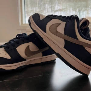 Nike Dunk Low - Nike Dunk Low, storlek 40,5, midnight navy/lt smoke grey. Sparsamt använda. Köpta för 1349 kr, kvitto och originallåda finnes. Kan skicka fler bilder. 