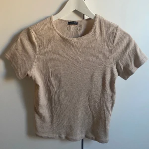 Beige t-shirt - Beige ribbstickad t-shirt som inte används längre. Storlek L men passar mig som är S. Den är liten i storlek 