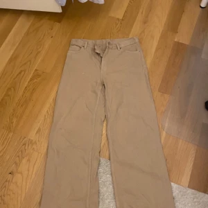 Baggy Beiga byxor - Köpta second hand. Oklart om storleken men måtten är: 41cm midja, 110cm längd och 26cm benöppning. Allt är mätt liggandes platt
