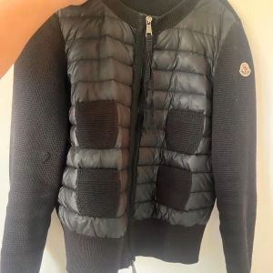 Moncler cardigan  - Moncler cardigan i storlek S. Använd men i bra skick. Defekt på ena ärmen som syns på bilden. 