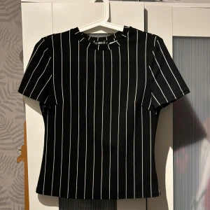 t-shirt svart med vita ränder  - köptes second hand men aldrig kommit till användning då den var för liten.  storleken ska vara S men känns mer som XS då shein går efter asiatiska storlekar som är mindre i jämförelse med europas storleks guide