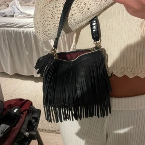 Svart flätad väska - Guldbandet är lite rostigt annars fin.