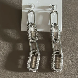 Kjedjeörhängen - Kjedjeörhängen med stenar. Bara använt 1 gång. Ej äkta silver. 