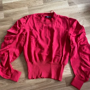 Röd långärmad tröja stl XS - Lite noppror på ena axeln, se bild.
