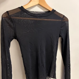 Meshtopp - Superfin tight långärmad topp i mesh-material. Väl använd men i väldigt fint skick! Säljes på grund av jag inte använder den längre.