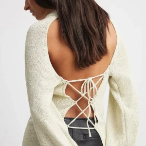 Stickad tröja med öppen rygg - Stickad tröja från Paola Cossentino x Nakd kollektionen. Köpt för 549!😊i storlek xs men passar även S-M pga snörningen. Pris kan diskuteras 