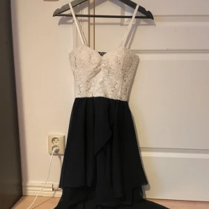Balklänning? - Använd endast en gång. Kort klänning med ett långt släp bak.