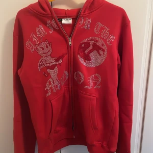 Aim For the Moon ziptröja - Röd ziptröja från Aim For the Moon! Använd max 8 gånger, inga defekter.  Alla stenar sitter kvar.  Storlek: M Köpt för 799:-