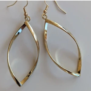 Guldörhängen i vriden design - Eleganta örhängen i guld med en vriden, oval form. Dessa örhängen har en enkel krok för enkel användning och en modern, stilren design, mycket fint skick 