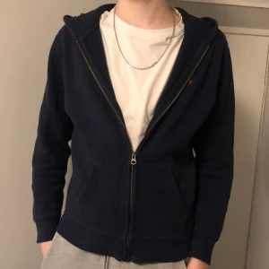Ralph lauren zipup - Det är en mörkblå zip up hoodie från polo ralph lauren. Plagget är i mycket bra skick, inga fläckar eller lösa trådar. Plagget har storleken L i barn och passar till en 14-16 åring. Hör av dig om du har någon fråga! ☺️