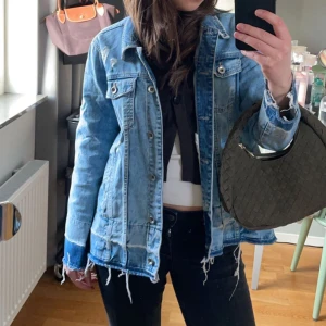 Ascool jeansjacka  - Säljer denna ascoola jeansjackan från Lindex men köpte på sellpy! Så snygg och passar perfekt till våren🩵🩵  Den har slitningar och fransar som är jättecoola och detaljerna gör plagget väldigt unikt😊😊