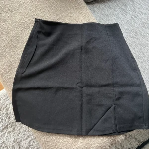 Svart kjol - Svart kjol ifrån Shein. Slitts fram. Oanvänd