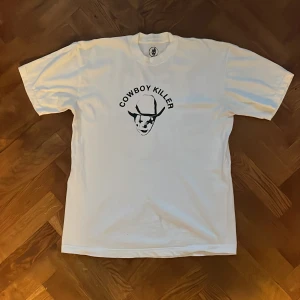 Crimecowboy tee  - Vit tshirt med tryck på båda sidor med en fläck på framsidan 