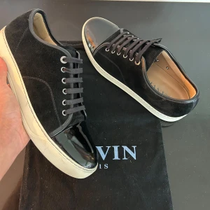 Lanvin skor - Ett par svarta lanvin sneakers i topp skick med glansig captoe. Skorna är i storlek UK 9 motsvarar 43. Väldigt bra skick 9/10. Skriv vid minsta fundering 💭 