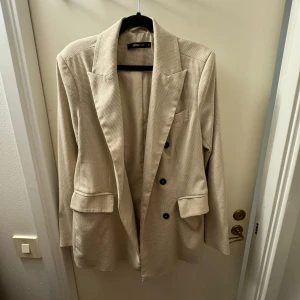 Beige kavaj - Snygg beige kavaj från Gina Tricot, fint skick. Storlek 40 och passar perfekt på mig som har 34-36 om man vill ha lite oversized
