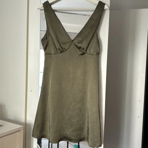 satin klänning  - Olivgrön klänning i satin. Använd 1 gång, som ny