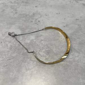 Justerbart armband från Skagen. Ena sidan är silver och andra sidan är guld, så man kan matcha detta med olika smycken beroende på vilken sida man bär. Aldrig använd.