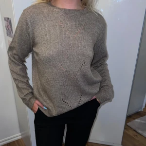 Beige stickad tröja från Vila - Säljer en superfin beige stickad tröja från Vila. Den är perfekt för höst och vinter med sin mysiga och varma känsla. Tröjan har långa ärmar och ett diskret mönster framtill. Den är i nyskick och passar perfekt till både jeans och kjol. Perfekt för en casual look eller att mysa i hemma. 💛