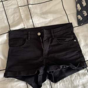 Säljer ett par svarta jeansshorts från H&M i storlek XS. De är lågmidjade och har en dragkedja och knapp framtill. Shortsen har två fickor fram och två bak, samt uppvikta benslut. Perfekta för sommaren! 🌞