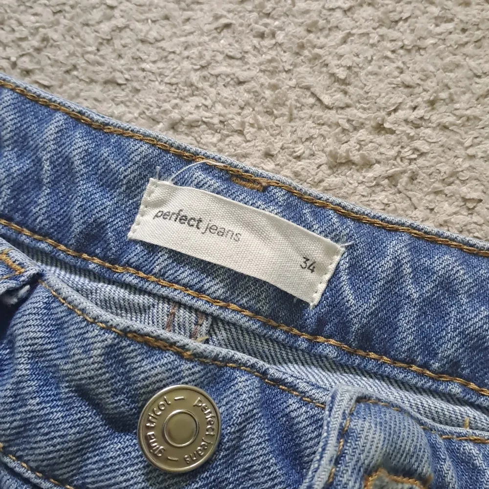 Blå bootcut jeans från Gina tricot. Har ett hål på knät och ett litet under den stora fickan, är 168 cm och de passar bra. Jeans & Byxor.