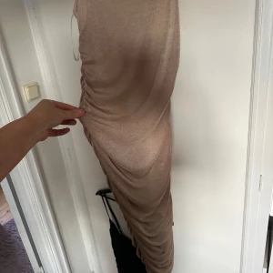 Glittrig beige klänning  - Storlek L  Stretchig material  Aldrig använd 