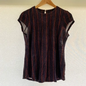 Lindex svartröd topp - Säljer en snygg svart och röd topp från Lindex. Den har ett coolt randigt mönster och är kortärmad. Bra skick. Storlek: S. Hör av er vid eventuella frågor!!