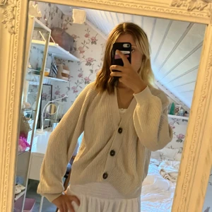 Beige stickad kofta från Lindex - Säljer en mysig beige stickad kofta från Lindex i storlek 158/164. Koftan har långa ärmar och knappar framtill. Den är perfekt för höst och vinter, men har ett litet slitage på ena ärmen. Annars i bra skick! Perfekt för att hålla sig varm och snygg under kyliga dagar. 🌟