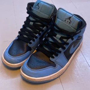 Nike Jordan 1 Mid svart/ljus blå  - Jag säljer mina gamla Jordan 1 Mid som jag har vuxit ur Skick 7,5/10 med tanke på liten skada på sista bilden  Pris kan diskuteras 