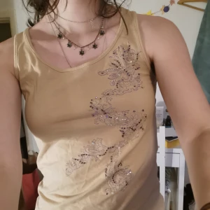 Broderad beige topp - Cool topp med lila broderi, köpt på secondhand. Bara meddela om du har några frågor 🌸  Jag som är på bilden har oftast storlek S