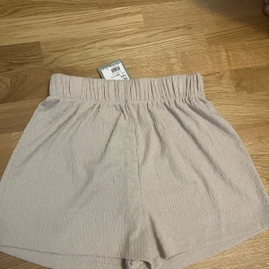 Shorts från H&M - Jag säljer ett par helt nya beige shorts i storlek XS. Shortsens prislapp är fortfarande kvar, vilket bekräftar att de är oanvända. Perfekta för sommaren eller sommarsemestern!💕