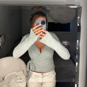 Omlott tröja  - Ljusblå omlotttröja i jätteskönt matreal