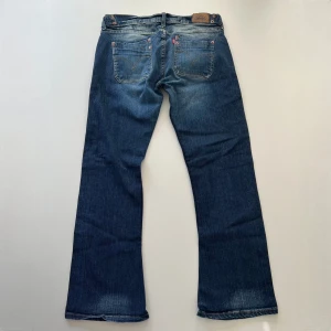 Levis 504 jeans - Vintage lågmidjade bootcut jeans från Levis. Midjemått: 82 cm, 41 cm rakt över. Stretchiga. Innerbenslängd: 77 cm. Min vän på bilderna är 167 cm 💓