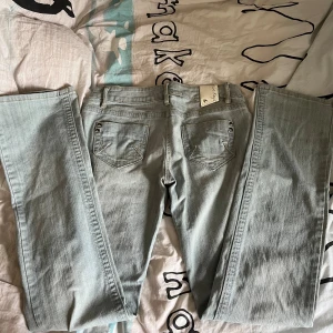 Lågmidjade jeans - Säljer dessa coola jeans eftersom de tyvärr inte passar mig, de är ljusblåa, utsvängda och lågmidjade. Använt 1-2 gånger och är i nyskick. Det är storlek 40 (M) men är lite små i storleken. 