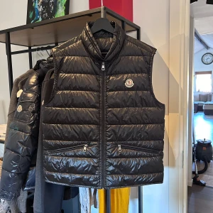 Moncler Gui Väst - Moncler Gui väst i nyskick, svart size 2 men äldre modell så sitter som en M och inte S/M som en 2a gör. Kommer med moncler authentication triangle, nypris 8400 mitt pris 3500. Bara att skriva vid frågor eller funderingar! Över 60 refs finns! :)