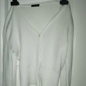 Vit kofta  - Säljer denna vita kofta i storlek M. Den är rymlig och stretchig, så passar förmodligen en M och S- storlek. Använd fåtal gånger och köpt på second hand. Tillverkad av luftigt material som också håller dig varm.