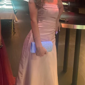 Balklänning - Säljer min jättefina ljusrosa silkes balklänning💗endast använd 1 gång. Den har några få glitter detaljer som syns på bilderna och en ”korsett” vid midjan som man drar åt med snören i bak. Jag är 168 och kunde ha ganska högra klackar till. 