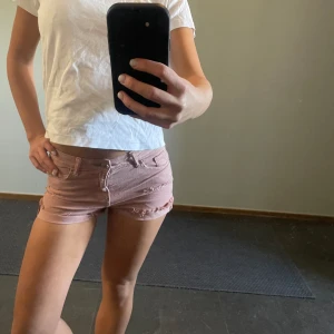 Slitna Lowwaist rosa shorts - Så fina i rosa och coola slitningar. Inga defekter. Aldrig använda. Köpa second hand. Jag brukar ha xs i kläder och dessa sitter som en smäck. 