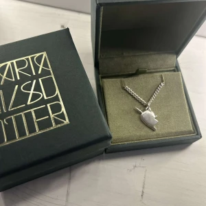 Maria Nilsdotter halsband  - Säljer halvhjärta från Maria Nilsdotter i silver. Använd fåtal gånger men ser helt nytt ut! Kedjan är i längd 45🫶🏼🫶🏼🫶🏼