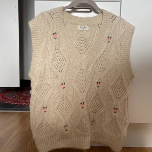 Blommig väst - Jättegullig väst med små rosor på. Storlek M och perfekt för layering då den är lite oversize. 