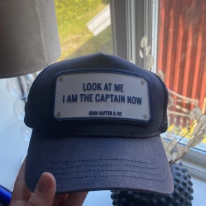 John hatten keps  - En marinblå John Hatter keps. Själv keps är i bra skick men lite solblekt.