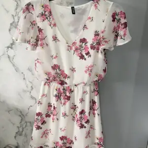 En jätte söt vit klänning med rosa blommor, perfekt till våren och sommaren!🌸 Säljer pga för liten för mig tyvärr. Klänningen är använd ett fåtal gånger utan några som helst defekter. 